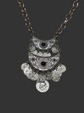 M.C’s bohemian silver-tone crescent moon statement necklace with engraved coin charms and dark stone accents.