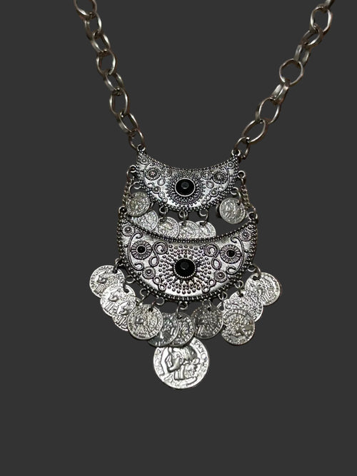M.C’s bohemian silver-tone crescent moon statement necklace with engraved coin charms and dark stone accents.