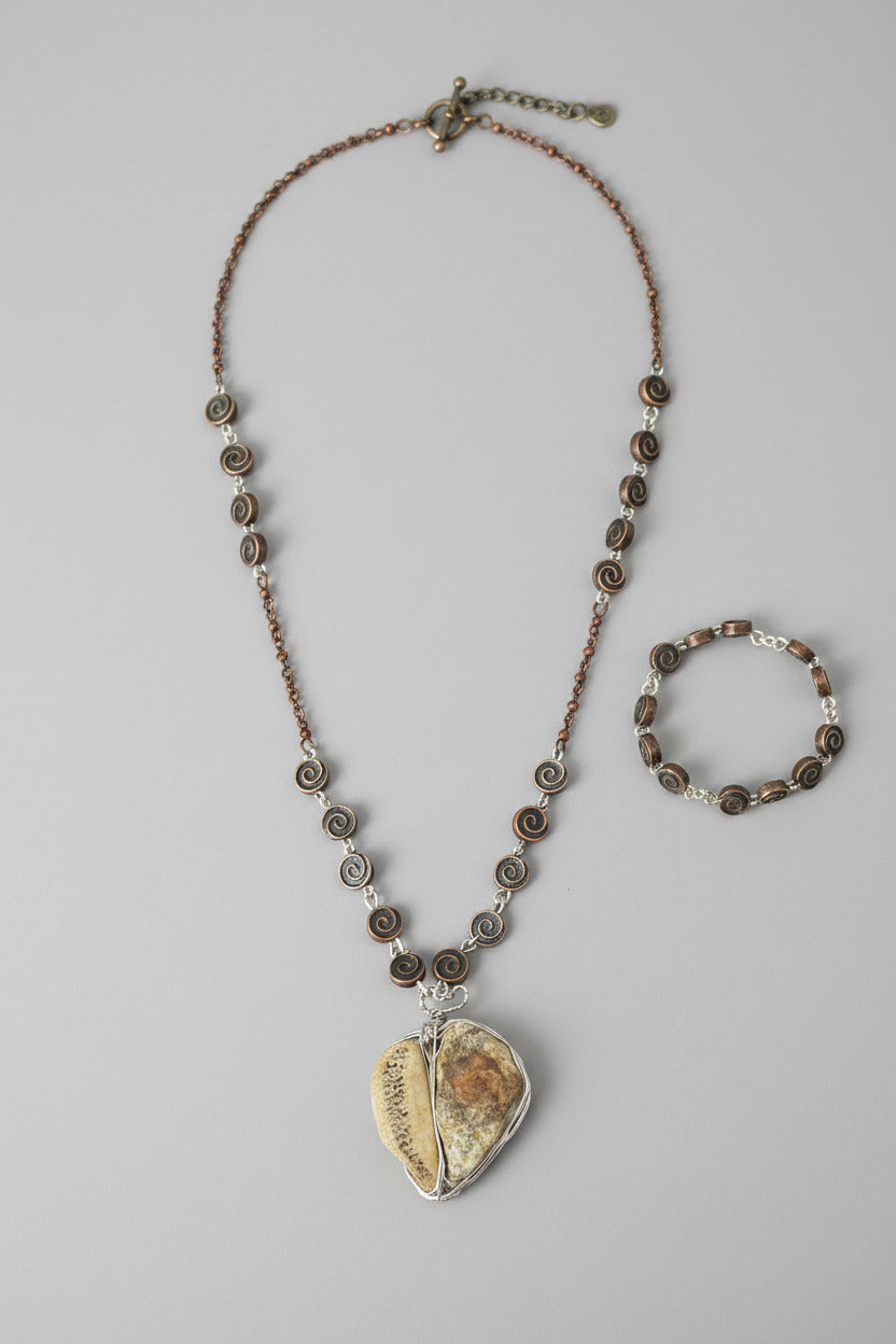 M.C’s artisan jewelry set featuring a wire-wrapped stone pendant necklace and matching spiral copper chain bracelet.