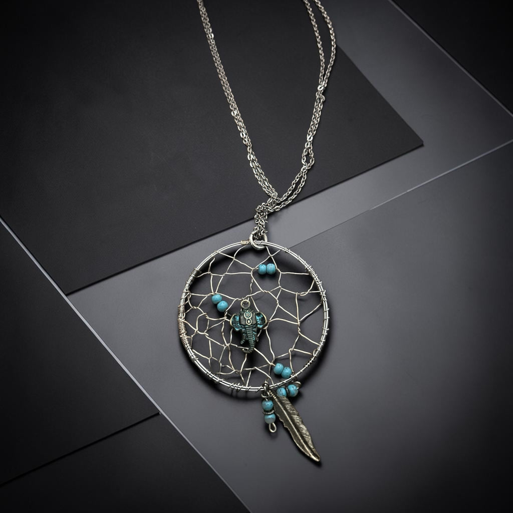 M.C’s bohemian dreamcatcher pendant necklace with turquoise beads, elephant charm, and silver feather on a chain.