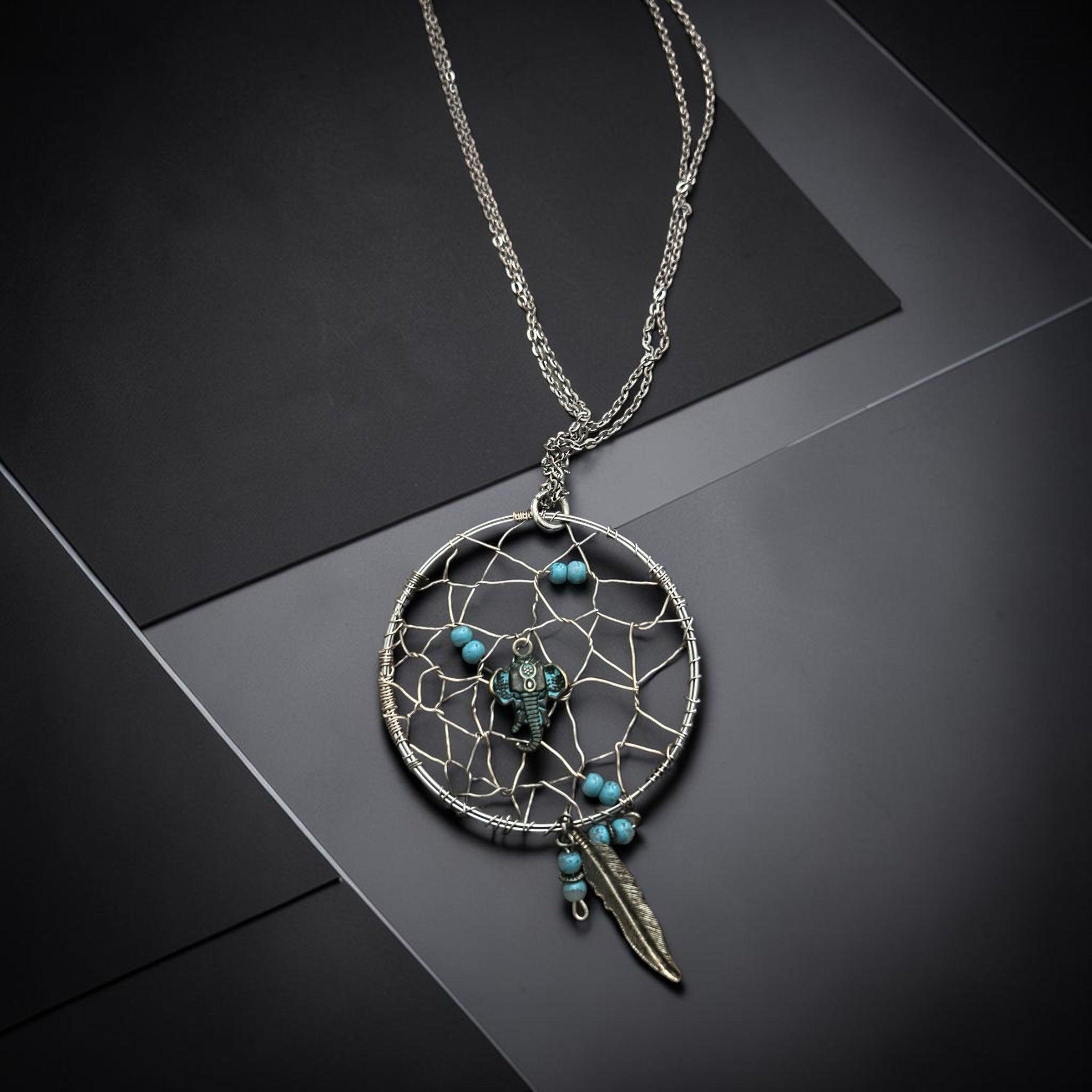M.C’s bohemian dreamcatcher pendant necklace with turquoise beads, elephant charm, and silver feather on a chain.