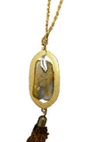 Moss Agate oval pendant necklace featuring an earth-toned stone, silver leaf accent, gold-tone frame, and dangling tassel.
