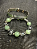 M.C’s two-piece bracelet set featuring a sage green leather cuff with Celebrate plate and mint stone beaded bracelet.