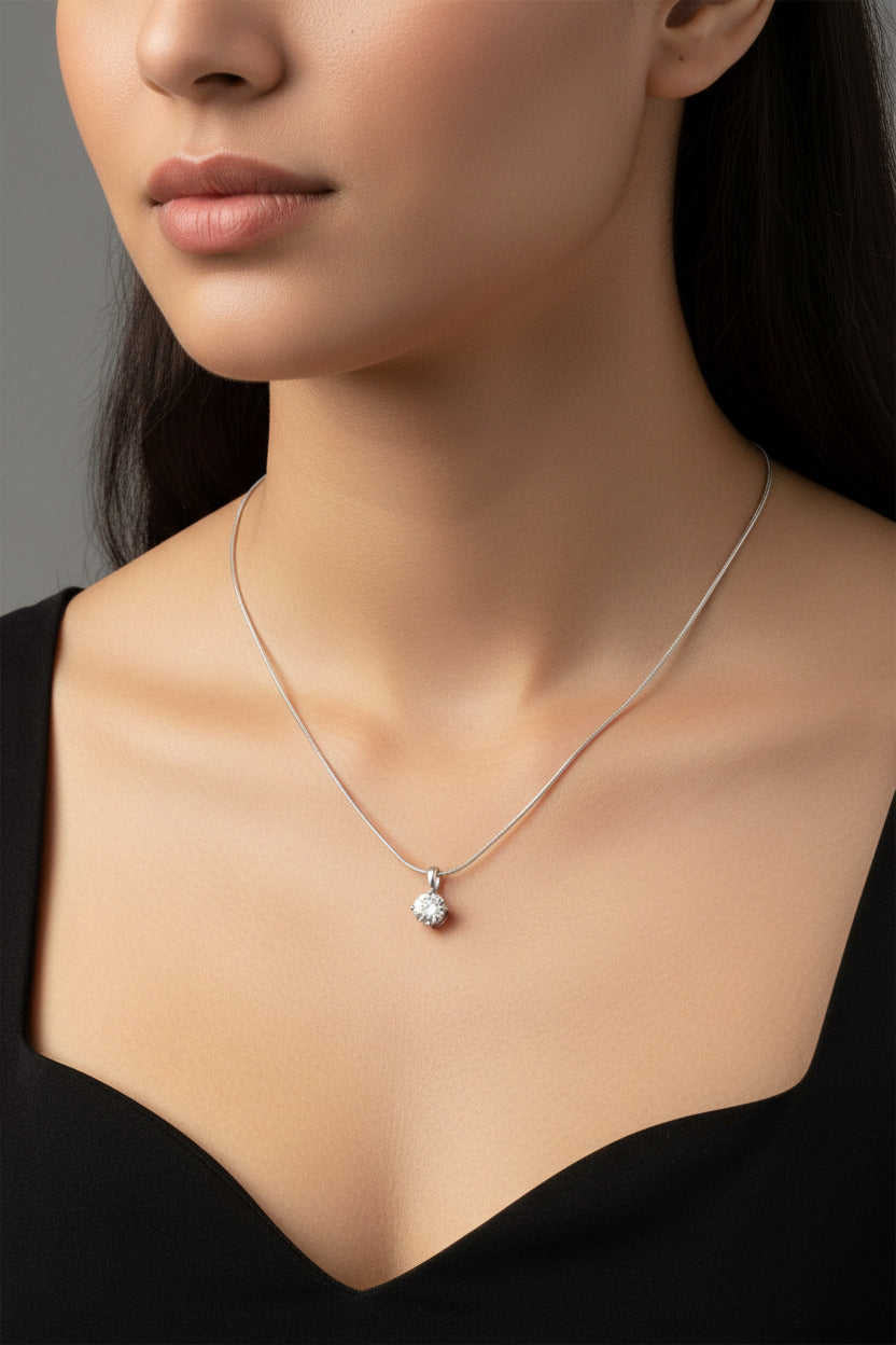 M.C’s solitaire pendant necklace featuring a round-cut clear stone on a silver-tone snake chain.